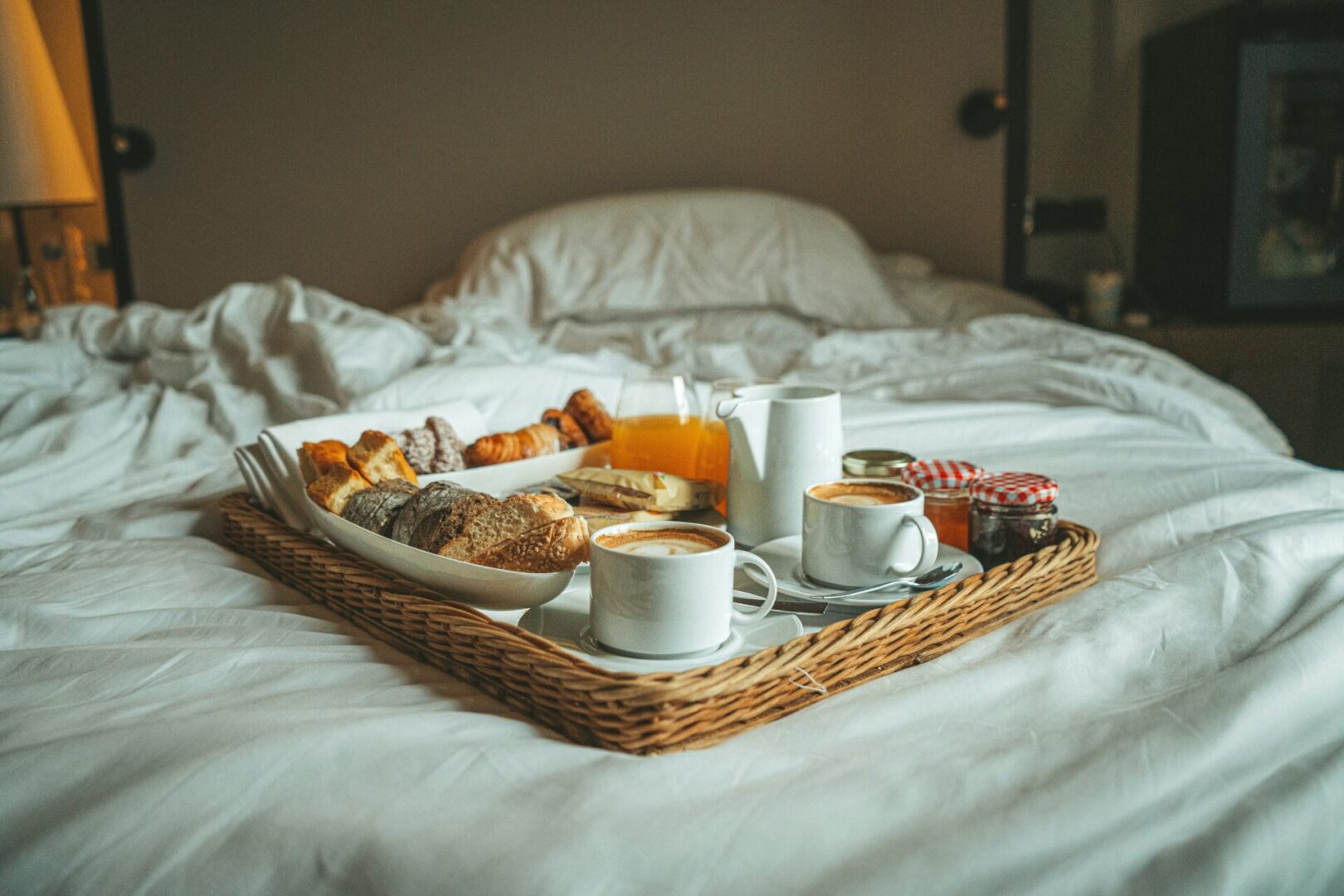 A tray of food on top of a bed.