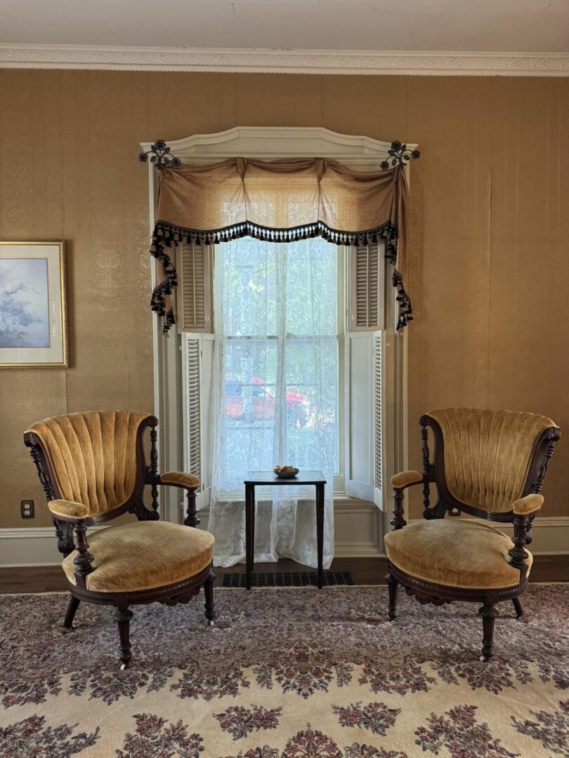 Two chairs and a table in front of a window.