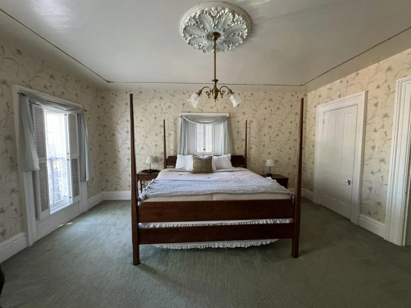 A bedroom with four poster bed and ceiling medallion.